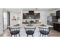 Modern kitchen with dark cabinets, island, and stainless steel appliances at 5259 Salt Marsh Rd, Wimauma, FL 33598