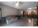 Living room with hardwood floors, gray couch, and view into kitchen at 10212 Grant Creek Dr, Tampa, FL 33647