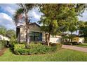 Landscaped home exterior showcasing a lush lawn and mature trees at 11976 Blazing Star Dr, Venice, FL 34293
