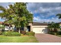 Attractive house exterior with a well-manicured lawn and a paved driveway at 11976 Blazing Star Dr, Venice, FL 34293