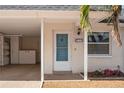 Front door entrance to condo, with carport and landscaping visible at 224 Sky Loch E Dr, Dunedin, FL 34698