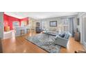 Open living space featuring hardwood floors and a red accent wall at 2852 Banyan Hill Ln, Land O Lakes, FL 34639