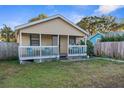 A yellow house with a porch, fenced yard, and driveway at 3436 51St N Ave, St Petersburg, FL 33714