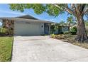 Spacious driveway leading to a light-blue house with a stone facade at 8134 Bayshore Dr, Seminole, FL 33776