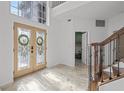 Light-filled foyer with a large window, decorative front doors, and access to a room with patterned floors at 22847 Sonoma Ln, Lutz, FL 33549