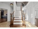 Elegant staircase featuring a wood and white design with decorative metal railings leading to the upper level at 22847 Sonoma Ln, Lutz, FL 33549