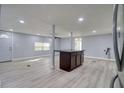 Open living space with kitchen island and light grey vinyl flooring at 4110 Wedgemere Dr, Tampa, FL 33610
