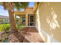 Charming entryway with brick walkway, leading to a screened-in porch and front door at 4817 Sandy Glen Way, Wimauma, FL 33598