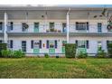 Two-story building with balconies, green accents, and manicured lawn at 200 Glennes Ln # 206, Dunedin, FL 34698