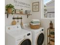 Well-organized laundry room with modern machines, shelving, decorative accents, and natural light from the window at 2066 San Marino N Way, Clearwater, FL 33763