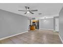 Spacious living room showcasing tile flooring, a ceiling fan, and an adjacent kitchen area at 209 Red Cedar Pl # 209, Brandon, FL 33510
