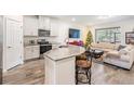 Open concept kitchen and living area with breakfast bar and large sectional sofa at 2919 Grand Kemerton Pl, Tampa, FL 33618