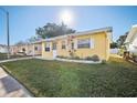 Ranch style home with a yellow exterior and neat landscaping at 5430 Palm Crest N Ct, Pinellas Park, FL 33782