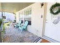 Relaxing front porch with teal chairs and decorative wreath at 7838 Avenal Loop, New Port Richey, FL 34655