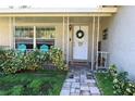Inviting front porch with decorative entry and comfortable seating at 7838 Avenal Loop, New Port Richey, FL 34655