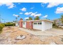 White and red brick home with a two-car garage and side yard at 204 163Rd Ave, Redington Beach, FL 33708