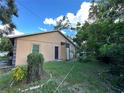 Large backyard with unkempt grass and some landscaping at 2103 E Nedro Rd, Tampa, FL 33604