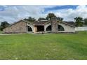 Stone exterior house with large windows and a spacious lawn at 5404 Glover Dr, Weeki Wachee, FL 34607