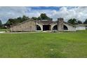 Stone exterior house with large windows and a spacious lawn at 5404 Glover Dr, Weeki Wachee, FL 34607