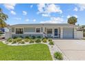 A charming single-story home featuring a driveway with manicured front yard landscaping at 709 Mandalay Ave, Clearwater Beach, FL 33767
