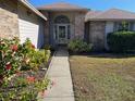 Front entry with walkway, landscaping, and brick exterior at 14905 Pelican Point Pl, Tampa, FL 33625