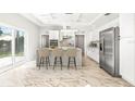 Bright kitchen features white cabinets, center island with seating, and access to backyard at 6117 E 113Th Ave, Temple Terrace, FL 33617