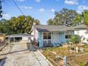Single story light blue house, carport and yard at 8416 N Semmes St, Tampa, FL 33604
