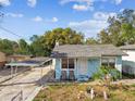 Small light blue house with carport and yard at 8416 N Semmes St, Tampa, FL 33604