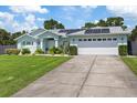 Single-story home with solar panels, a two-car garage, and well-manicured lawn at 12437 Meinert Ave, Brooksville, FL 34613