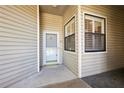 Exterior condo entry with a light gray door and window at 3127 W Sligh Ave # 203B, Tampa, FL 33614