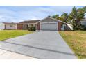 Brick ranch home with a two-car garage and landscaped lawn at 3438 Moog Rd, Holiday, FL 34691