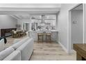 Open-concept living room showcases kitchen with marble counters, modern appliances, and hardwood floors at 6602 S Emerson Ave, St Petersburg, FL 33707
