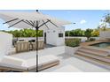 Inviting rooftop deck area with a white parasol, outdoor seating, dining, a mini-pool, and serene skyline views at 7602 Antilla St, Tampa, FL 33625