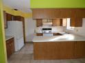 Wood kitchen cabinets, tile floor, and a white refrigerator at 8510 Renald Blvd, Temple Terrace, FL 33637