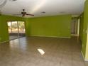 Bright lime green living room with tile floors and sliding glass doors at 8510 Renald Blvd, Temple Terrace, FL 33637