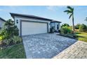 Single-story house with a white garage door and landscaped front at 8705 Coastal Key Way, Parrish, FL 34219