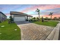 One-story house with a brick paver driveway and palm trees at 8705 Coastal Key Way, Parrish, FL 34219