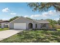 Charming single-story home features a manicured lawn, a gray exterior, and a two-car garage at 1009 Black Knight Dr, Valrico, FL 33594