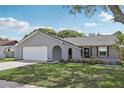 Charming single-story home features a manicured lawn, a gray exterior, and a two-car garage at 1009 Black Knight Dr, Valrico, FL 33594