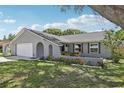 Charming single-story home features a manicured lawn, a gray exterior, and a two-car garage at 1009 Black Knight Dr, Valrico, FL 33594