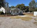 Single story home with green roof, stone facade, and a large yard at 16118 Hanna Rd, Lutz, FL 33549