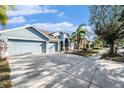 Light blue house with a two-car garage and a long driveway at 2619 Yukon Cliff Dr, Ruskin, FL 33570