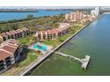Waterfront condominium complex featuring a community pool and dock access on a sunny day at 7550 Sunshine Skyway S Ln # T48, St Petersburg, FL 33711