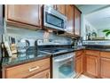 Stainless steel appliances and granite countertops in a well-lit kitchen at 10280 Post Harvest Dr, Riverview, FL 33578