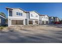 Three-unit townhome building under construction, offering attached garages at 5727 Desert Rose Pl, Tampa, FL 33615