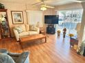 Bright living room with laminate flooring, comfortable seating, and a large TV at 9790 66Th N St # 340, Pinellas Park, FL 33782