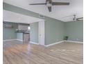 Spacious living room with light wood floors and soft green walls at 115 Canal Ave # 1, Indian Rocks Beach, FL 33785