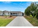 Newly renovated light blue house with a long driveway at 1201 Harkness Way, Sun City Center, FL 33573