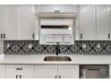Close-up of the kitchen sink with a modern faucet and decorative tile backsplash at 1201 Harkness Way, Sun City Center, FL 33573