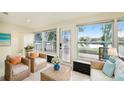 Cozy sun room with wicker furniture, large windows, and a door with serene lake view, perfect for relaxation at 12506 Forest Hills Dr, Tampa, FL 33612